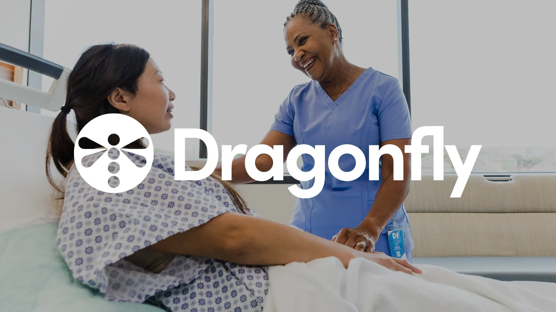 Patient in bed with a healthcare professional talking to them.