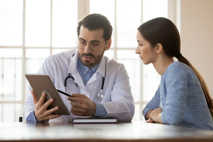 A physician shares results with a patient via a tablet.