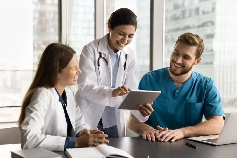 A care team consults on a patient while accessing data from an AI-driven software application.