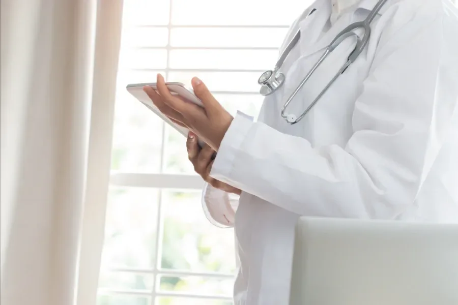 A physician consults data on a tablet to assist in decision-making.
