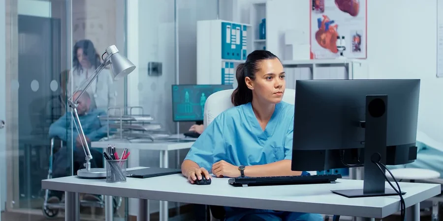 A nurse accesses AI software on a desktop PC in a hospital.