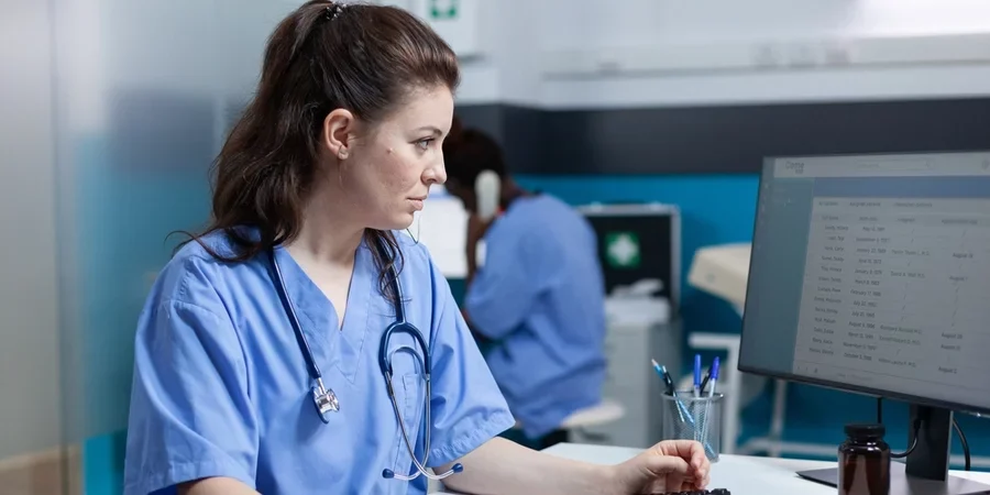 A nurse accesses AI data on a desktop computer.
