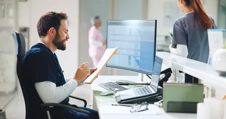 A smiling nurse accesses AI tools while performing administrative tasks.